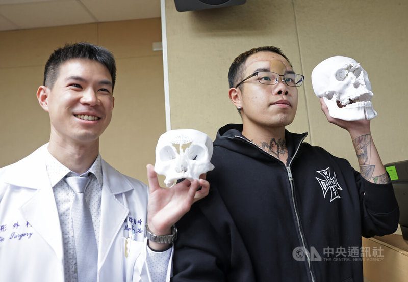 三軍總醫院日前接獲遭槍傷導致臉骨粉碎、腦部直接暴露的患者，醫療團隊透過3D列印模型輔助手術規劃，成功讓患者重獲自然五官比例，26日舉行記者會發表，整形外科主治醫師徐國峰（左）與顱顏重建患者開心合影。中央社記者裴禛攝　114年11月26日