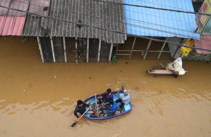 氣旋迪特瓦在斯里蘭卡引發豪雨和洪患，圖為民眾乘船通行。（路透社）
