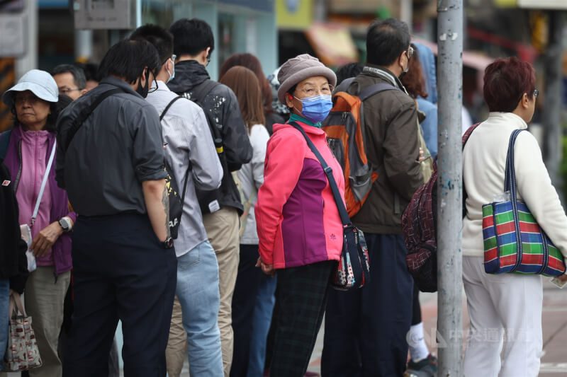 圖為新北市土城區戶外候車民眾戴上帽子保暖。（中央社檔案照片）