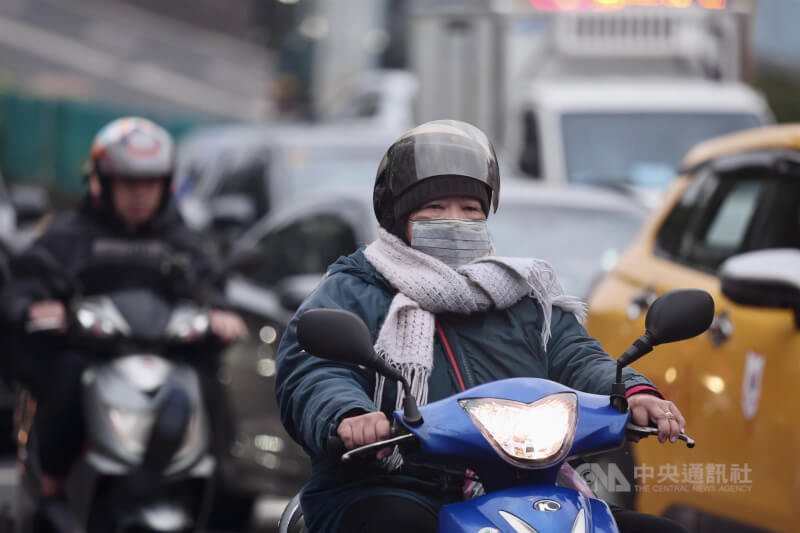 氣象署24日表示，東北季風將增強，預估25日晚至26日清晨最冷，嘉義以北平地低溫探攝氏14度。圖為寒風中的台北市松山區街頭機車騎士。（中央社檔案照片）