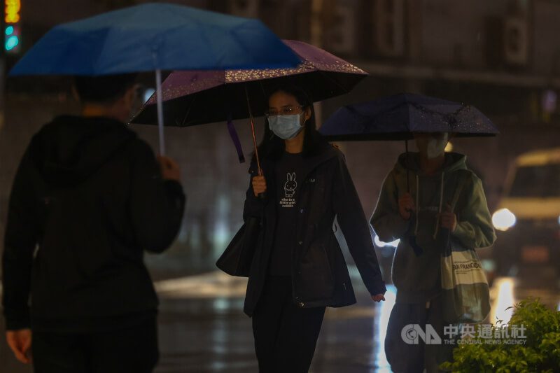 中央氣象署表示，26日晚間起水氣增多，桃園以北、東半部地區及恆春半島有局部短暫雨，預計持續至27日晚間。圖為新北市板橋區街頭撐傘民眾。（中央社檔案照片）