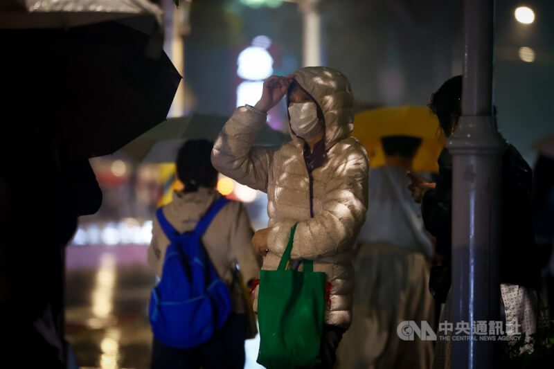 圖為新北市板橋區街頭民眾穿上羽絨外套禦寒。（中央社檔案照片）