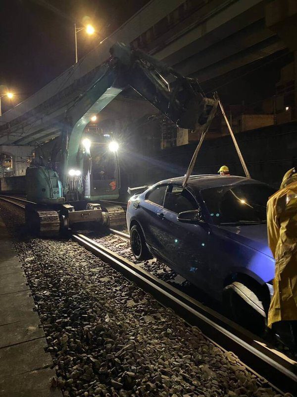 通緝犯黃姓男子26日凌晨2時許開車拒檢，衝入基隆市一處平交道，飆駛鐵軌不久後爆胎，黃男棄車逃逸；台鐵調派怪手於凌晨4時50分將車輛移到路線外。（讀者提供）中央社記者王朝鈺傳真　114年11月26日