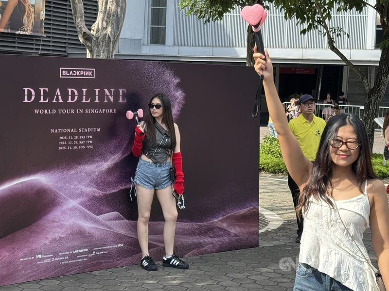 韓國女團BLACKPINK 11月28日至30日在新加坡巡演。圖為粉絲29日在新加坡國家體育場外與活動背板拍照。中央社記者吳昇鴻新加坡攝　114年12月1日