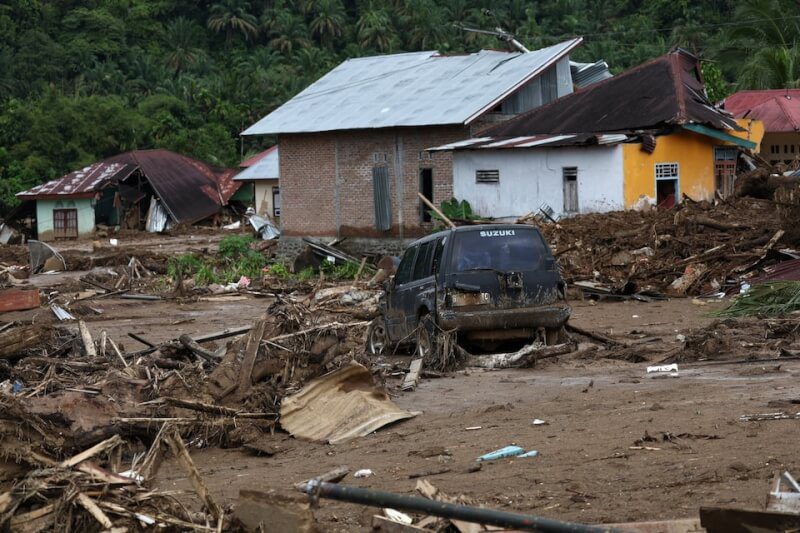 季風豪雨跟兩個熱帶氣旋侵襲南亞後，印尼西蘇門答臘省一處村庄的汽車仍陷在泥濘中。（路透社）
