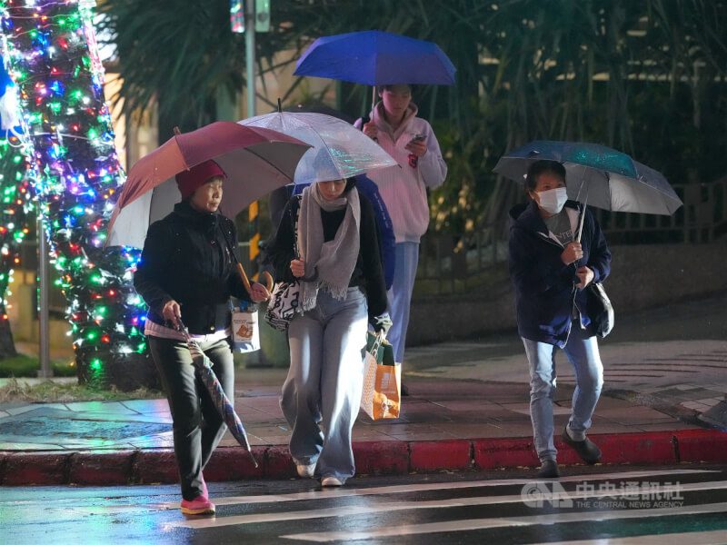 氣象署表示，9日水氣偏多，基隆北海岸、大台北山區及宜蘭防局部大雨。14日、15日局部平地低溫探攝氏10、11度。圖為民眾穿上禦寒衣物撐傘在台北市北投區過馬路。中央社記者徐肇昌攝　114年12月8日