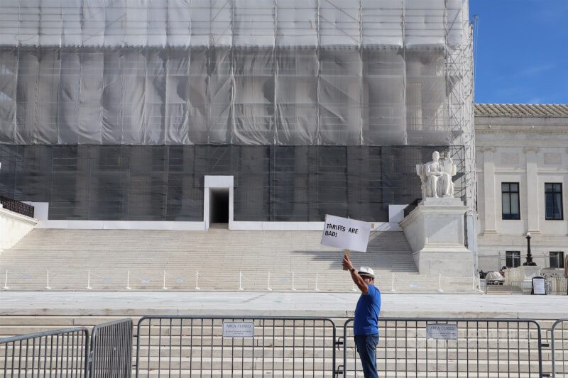 美國最高法院11月5日就美國總統川普是否有權依法加徵關稅進行約2.5小時的辯論，民眾在最高法院外舉牌抗議。（中央社檔案照片）